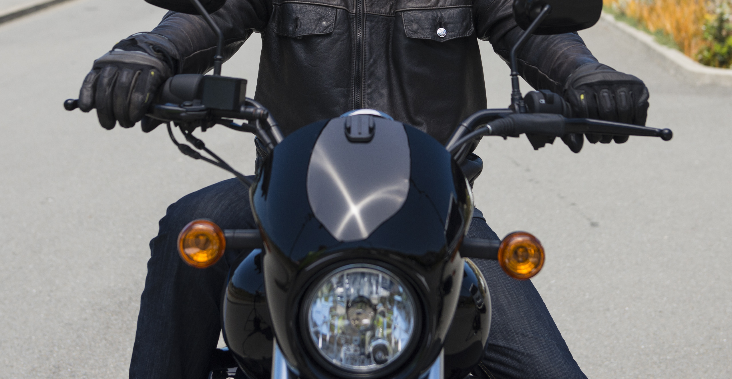 Close up of the front of a cruiser bike with rider