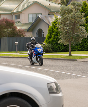 Bike riding straight with car on side street to the right