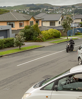 Bike riding straight with car on side street to the left