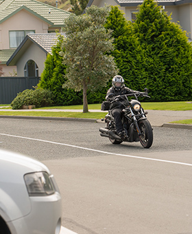 Bike riding straight with car on side street to the right