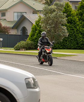 Bike riding straight with car on side street to the right